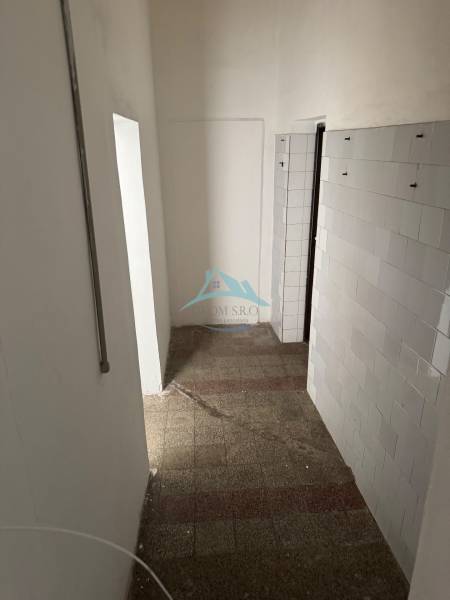 Obchodné priestory na predaj centrum mesta Šahy - Úzky interiér s dlažbou a obloženou stenou v obchodných priestoroch.