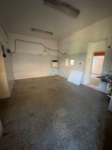 Obchodné priestory na predaj centrum mesta Šahy - Interiér obchodných priestorov so staršími obkladmi a dlažbou, prázdna miestnosť s umývadlom.