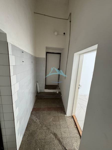 Obchodné priestory na predaj centrum mesta Šahy - Úzky chodba s dlaždicovými stenami a svetlom v obchodných priestoroch.