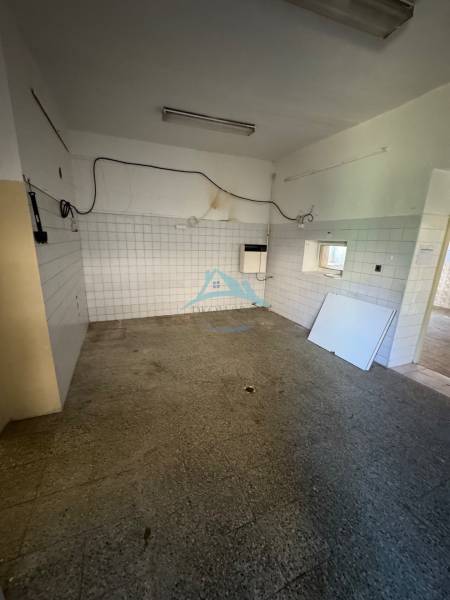 Obchodné priestory na predaj centrum mesta Šahy - Prázdny interiér s dlaždicami a betónovou podlahou v obchodných priestoroch.