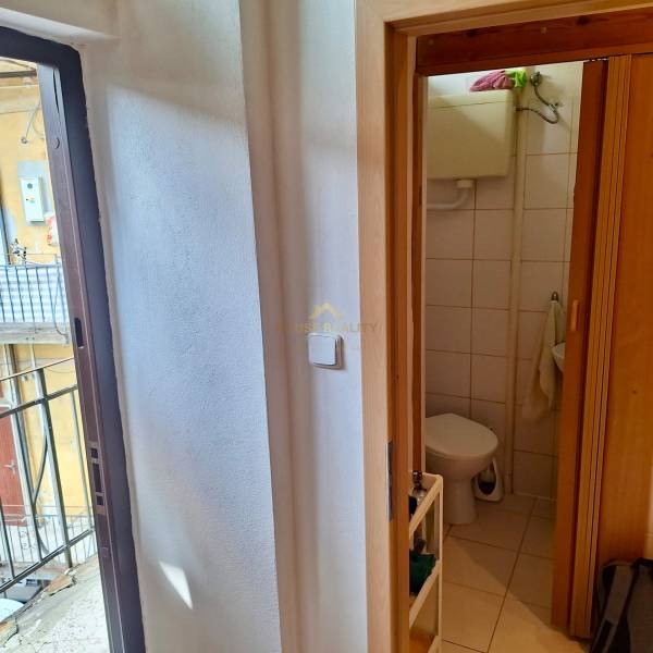 Predaj 1 izbový byt, Karpatská ulica, Bratislava I. Staré Mesto - V 1-izbovom byte vidieť kúpeľňu s toaletou a dvere vedúce na balkón.