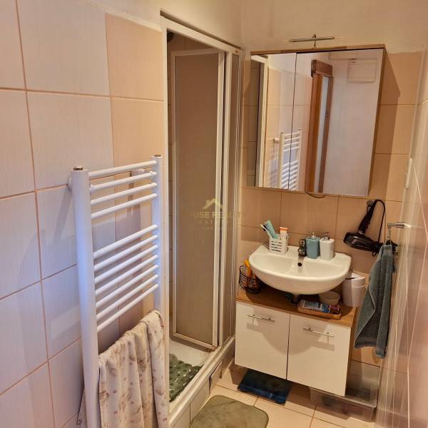 Predaj 1 izbový byt, Karpatská ulica, Bratislava I. Staré Mesto - Kúpeľňa v 1-izbovom byte s umývadlom, sprchovým kútom a radiátorom na uteráky.