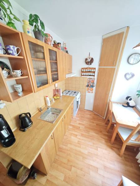 REZERVOVANÉ: 2 izb byt 56m2 pôvodný stav s balkónom, Družby Fončorda  - Kuchyňa v 2-izbovom byte s dreveným nábytkom, kútom na stolovanie a dekoráciami.