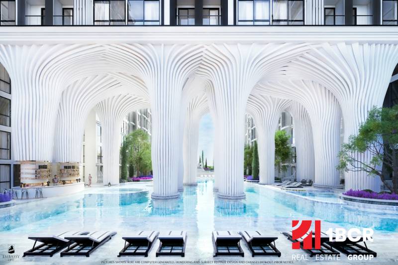 EMBASSY LIFE PATTAYA - Luxusná výstavba bytov s bazénom a bielymi stĺpmi pripomínajúca futuristickú architektúru.