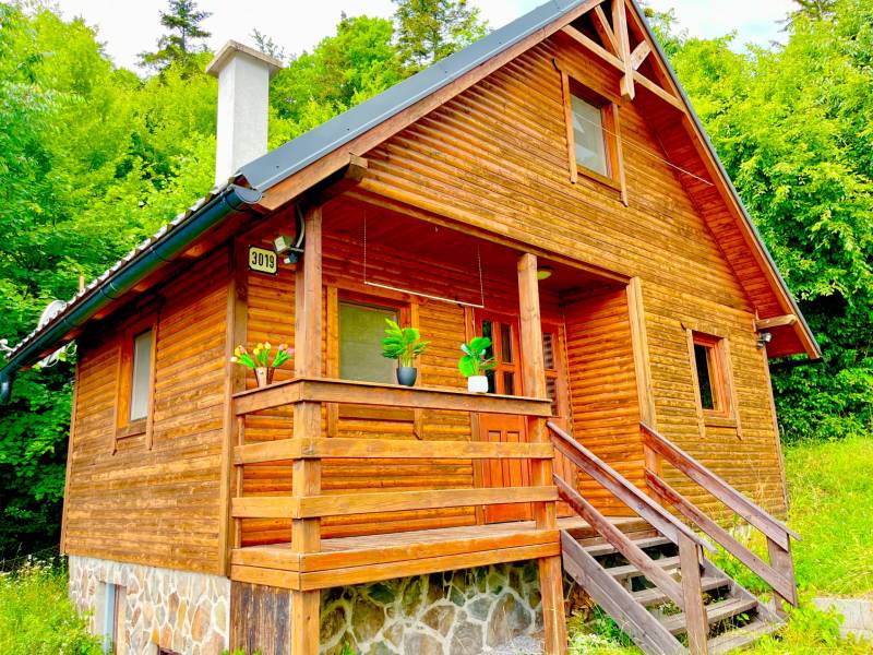 Rekreačná chata – Banská Štiavnica, časť Štefultov - Drevený rodinný dom v Štefultove s kamenným základom, obklopený zeleňou.