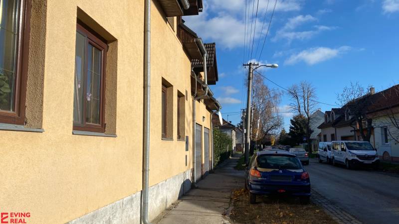 Dvojgeneračný 6 izb. RD,  vyhľadávaná  pokojná lokalita, Ružinov - Rodinný dom na Stachanovskej ulici, vedľa zaparkované autá a viditeľný modrý Peugeot.
