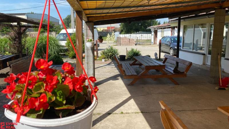Penzión s 13 izbami na predaj, Dunajská ul., Tomášov - Na ulici s kvetinovým závesom, lavicou a autami, blízko hotely a penzióny.