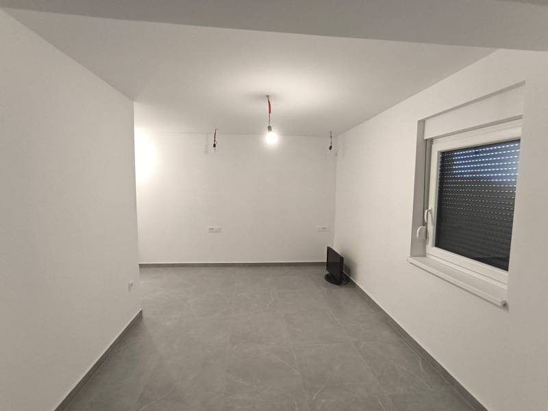 CHORVÁTSKO - Atraktívny apartmán (S6) - Mandre, ostrov Pag - Prázdna miestnosť v 4-izbovom byte s bielymi stenami a sivou podlahou.