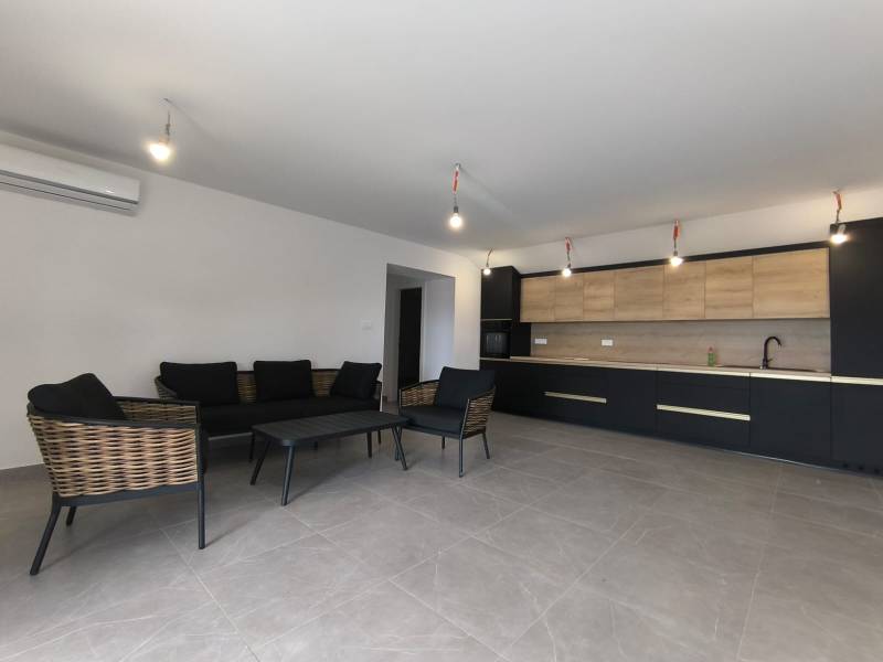 CHORVÁTSKO - Atraktívny apartmán (S6) - Mandre, ostrov Pag - Obývací priestor 4-izbového bytu s tmavým nábytkom a kuchyňou s drevenými detailmi.