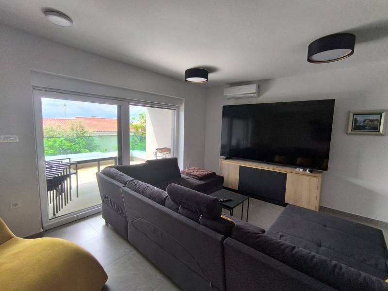CHORVÁTSKO - Atraktívny apartmán (S4) - Mandre, ostrov Pag - Obývačka v 4-izbovom byte so sedačkou, TV a výhľadom na terasu.