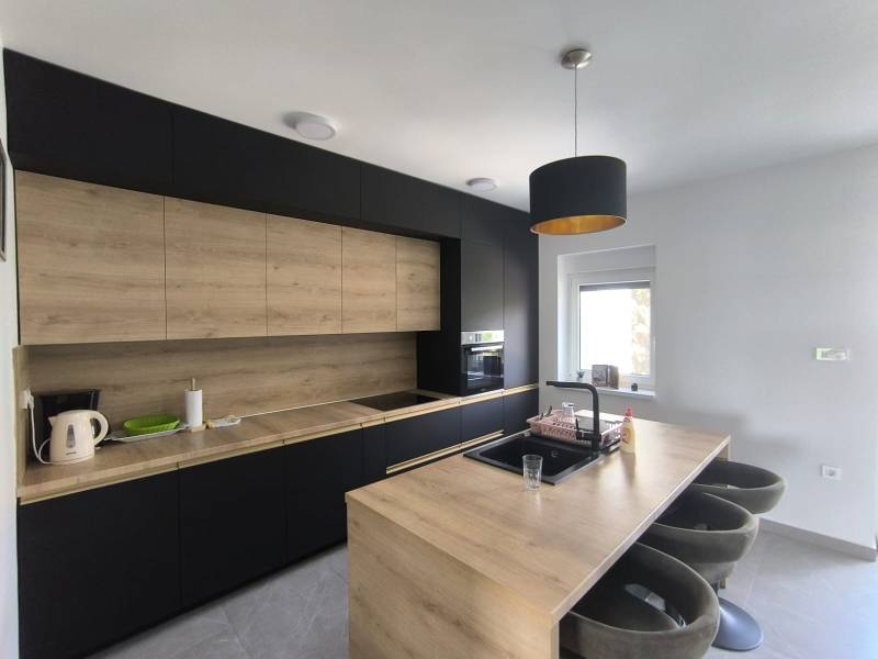 CHORVÁTSKO - Atraktívny apartmán (S4) - Mandre, ostrov Pag - Kuchyňa v 4-izbovom byte s dreveným a čiernym nábytkom a barovými stoličkami.