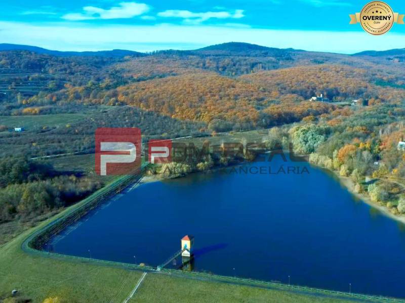 Na PREDAJ krásny slnečný pozemok s chatkou neďaleko Bratislavy - Jazero obklopené jesennou krajinou v oblasti Pezinka, vhodné pre Pozemky - bývanie.