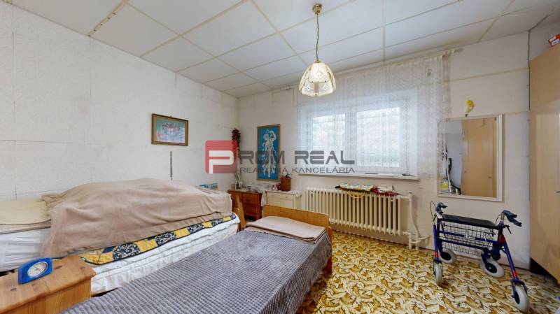 Na PREDAJ rodinný dom vo výbornej lokalite Bratislava - Ružinov - Izba s posteľou, koberec a chodítko v rodinnom dome.