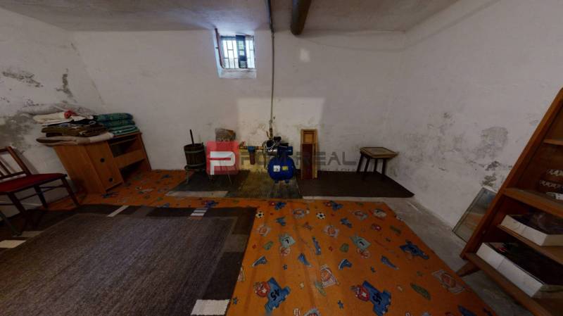 Na PREDAJ rodinný dom vo výbornej lokalite Bratislava - Ružinov - Suterén rodinného domu s malým oknom, koberec a vnútorné zariadenie vrátane kresla.