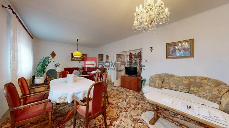 Na PREDAJ rodinný dom vo výbornej lokalite Bratislava - Ružinov - Obývacia izba v rodinnom dome s nábytkom, koberec, luster, závesy a obrazy.