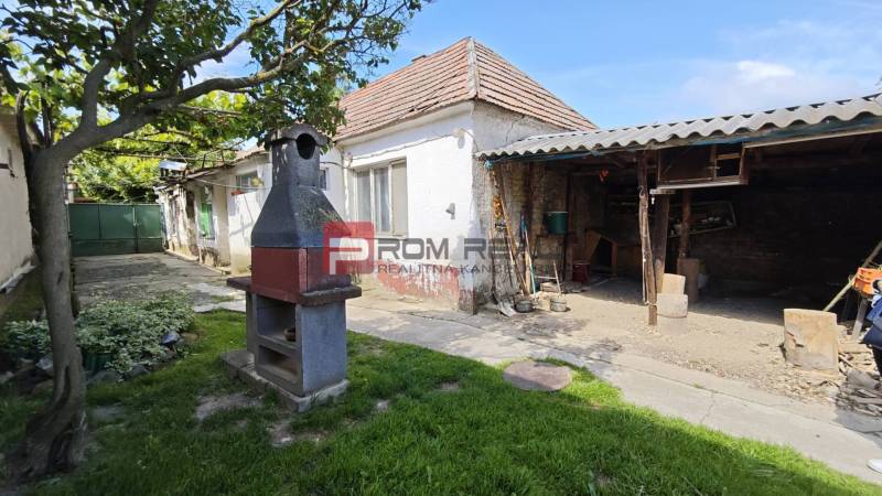 Na PREDAJ veľkorysý pozemok so starším domom v obci Dolné Orešany - Vo dvore v centre Dolných Orešian je záhradný krb a altánok. Pozemky - bývanie.