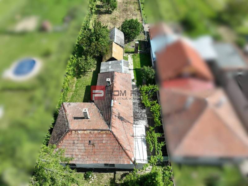 Na PREDAJ veľkorysý pozemok so starším domom v obci Dolné Orešany - Letecký pohľad na dom obklopený zeleňou v Dolných Orešanoch, centrum, Pozemky - bývanie.