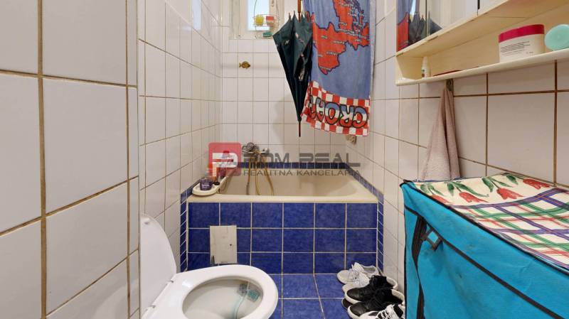 Na PREDAJ byt rozdelený na dve bytové jednotky Staré Mesto - Kúpeľňa v 2-izbovom byte s vaňou obloženou modrými kachličkami.