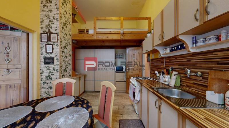 Na PREDAJ byt rozdelený na dve bytové jednotky Staré Mesto - Kuchyňa s jedálenským stolom a galériou v 2-izbovom byte, drevený a tehlový dekor.