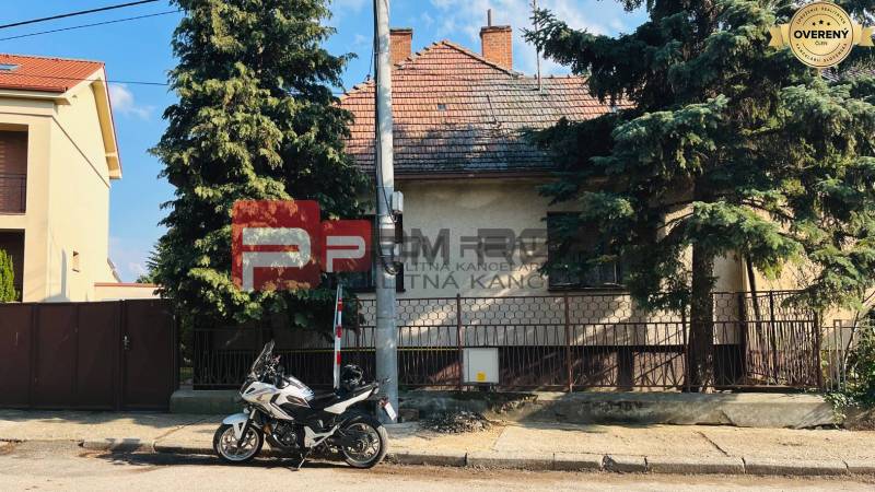 Exkluzivne na PREDAJ Rodinný dom Pezinok Nerudová ul. - Rodinný dom na Nerudovej ulici v Pezinku, pred ním zaparkovaná motorka.