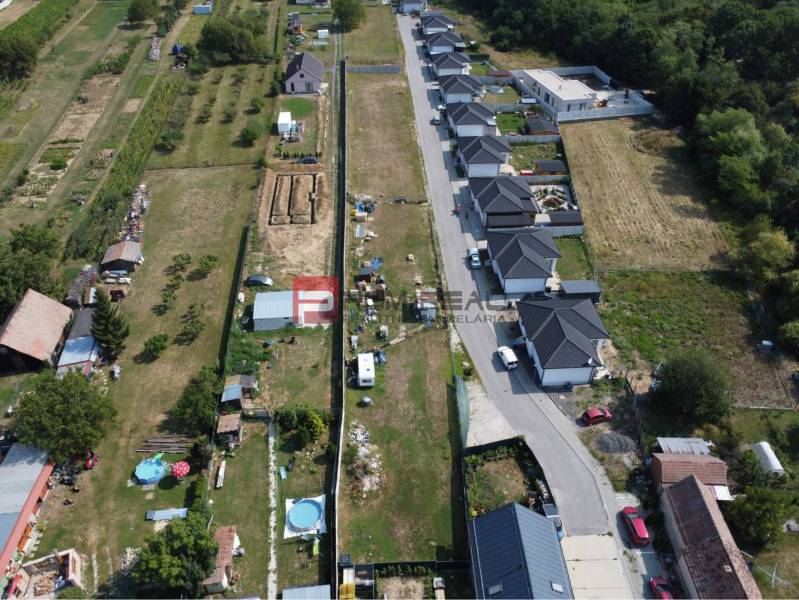 Stavebný pozemok so stavebným povolením a projektom na dvojdom - Letecký pohľad na pozemky pre bývanie v Štefanovej, susediace s radovou výstavbou domov.