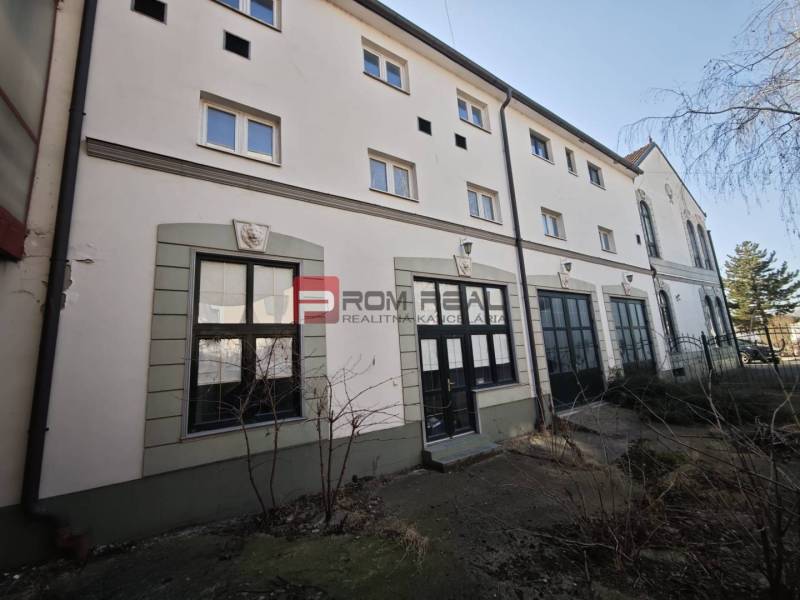 EXKLUZÍVNA INVESTÍCIA: MULTIFUNKČNÁ BUDOVA NA PREDAJ, TRNAVA - Na ulici Ľ. Podjavorinskej sa nachádza budova s veľkými oknami a historickými detailmi.