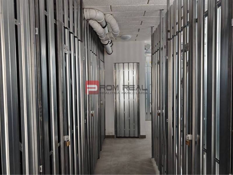 PREDAJ 2i byt, 110 m2, Prémiová novost. Zelené Nivy, Pezinok - Skladové priestory s plechovými dverami a trubkami na strope v 2-izbovom byte.