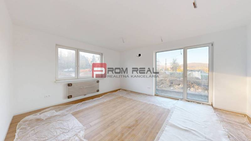 PREDAJ 2i byt, 110 m2, Prémiová novost. Zelené Nivy, Pezinok - Izba s drevenou podlahou a veľkými oknami poskytuje svetlosť v 2-izbovom byte.