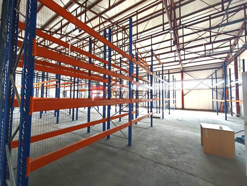 PRENÁJOM - zateplená skladová hala 547 m2, Modra - Regály v interiéri skladov a hál s okenným osvetlením a betónovou podlahou.