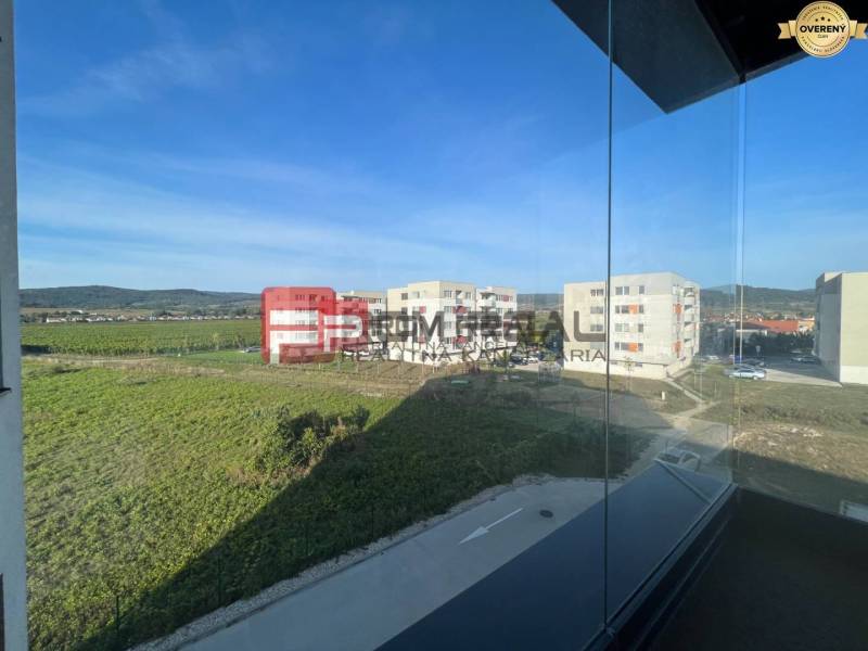 NA Predaj 4 izbový byt v projekte VINICE Pezinok 150m2 - Výhľad z 4-izbového bytu na Obchodnej ulici v Pezinku na okolie a budovy.