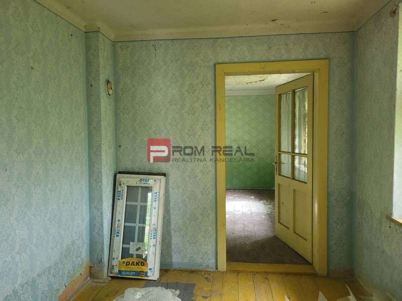 PREDAJ pozemku so starým domom CENTRUM Pezinok - Interiér s tapetami a starou podlahou, Pozemky - bývanie. Dodáva vidiecku atmosféru.