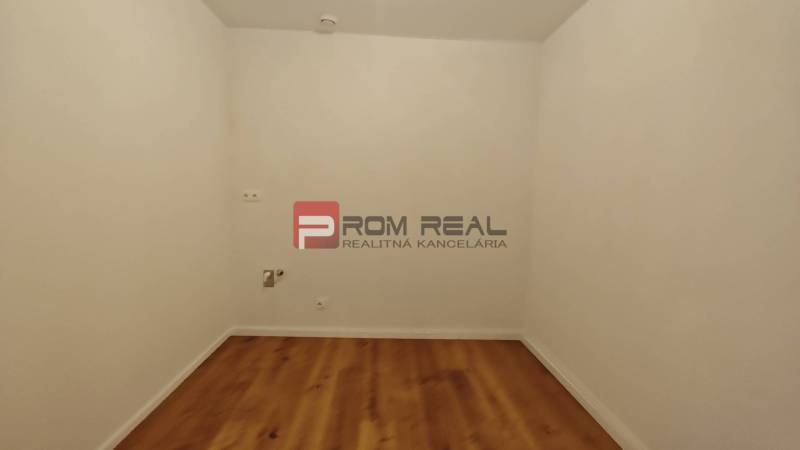 NA Predaj 4 izbový byt v projekte VINICE Pezinok 150m2 - Izba s bielymi stenami a drevenou podlahou v 4-izbovom byte.