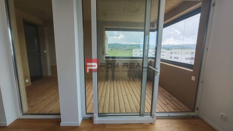 NA Predaj 4 izbový byt v projekte VINICE Pezinok 150m2 - Sklenené dvere vedú na lodžiu v 4-izbovom byte s výhľadom na kopce.