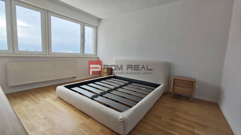 NA Predaj 4 izbový byt v projekte VINICE Pezinok 150m2 - Svetlá spálňa s drevenou podlahou a posteľou v 4-izbovom byte.