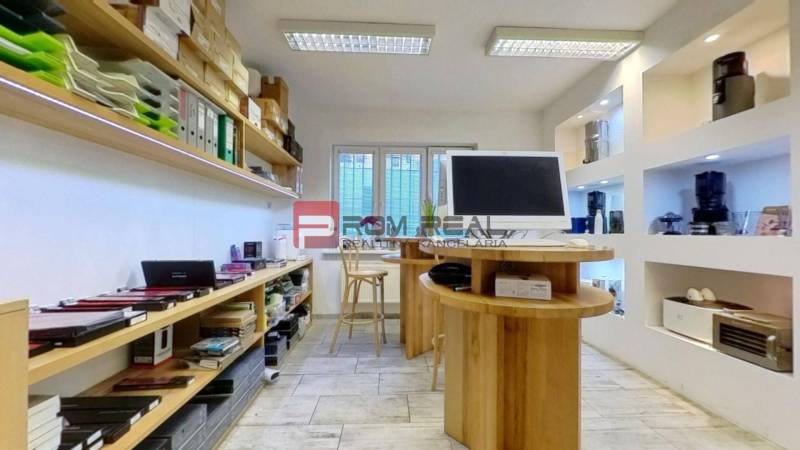 Obchodný priestor v centre Bratislavy Grösslingova ulica - Obchodné priestory s policami plnými dokumentov, prístrojmi a počítačom na stole.