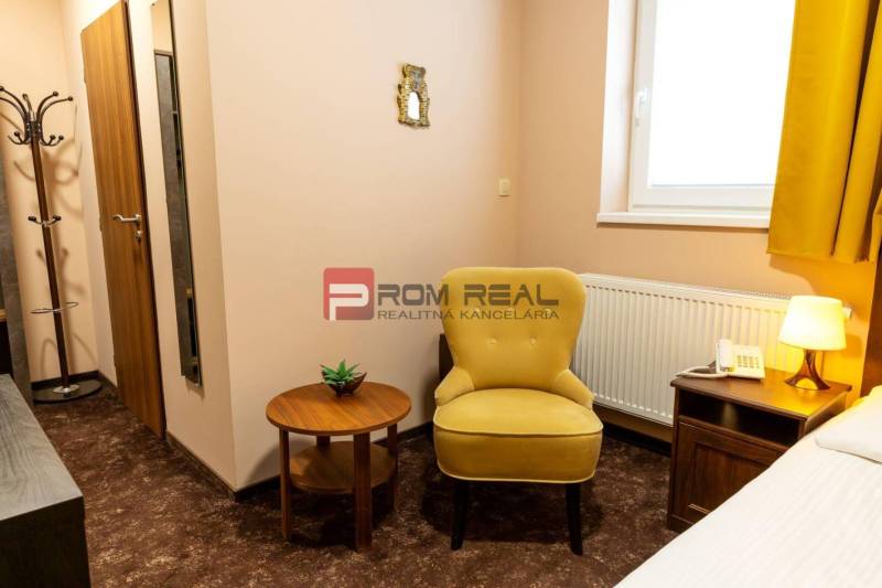 PREDAJ B&B Hotel v Starom meste - škola, centrum medicíny - Hotelová izba s kreslom, stolíkom, lampou a telefónom, vhodná pre relax.