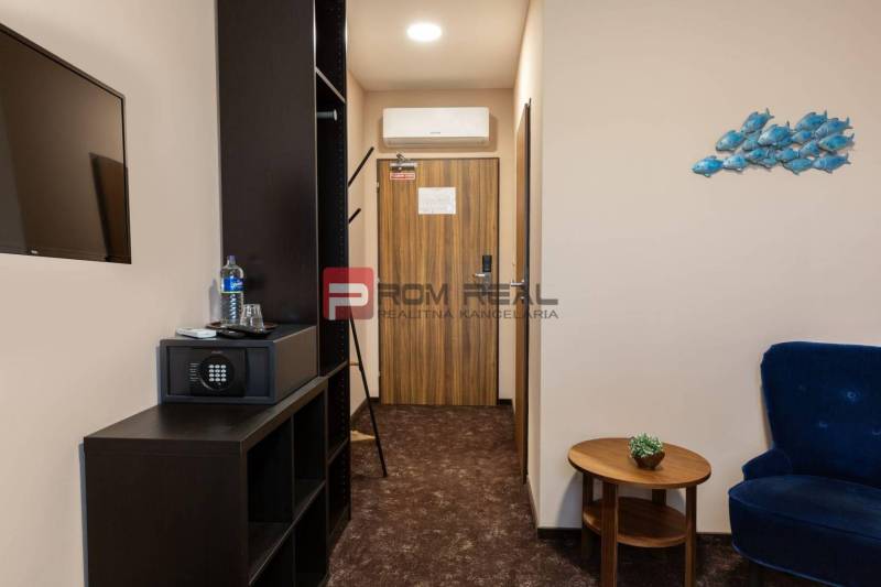 PREDAJ B&B Hotel v Starom meste - škola, centrum medicíny - Izba v hoteli s nábytkom, trezorom a televízorom, dekorácie na stene.