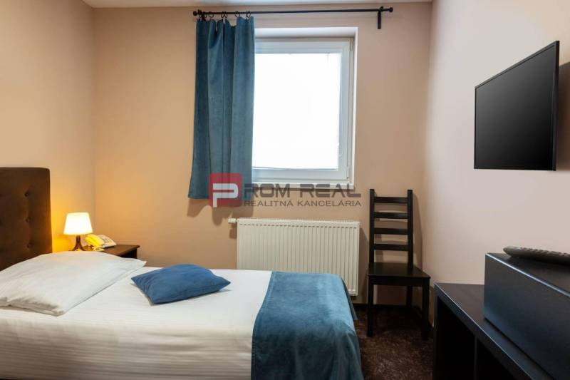 PREDAJ B&B Hotel v Starom meste - škola, centrum medicíny - Izba s posteľou, lampou, televízorom a oknom v ubytovacom zariadení.