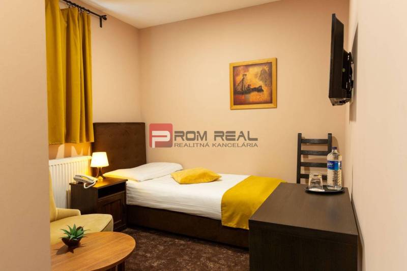 PREDAJ B&B Hotel v Starom meste - škola, centrum medicíny - Útulná izba s posteľou, kreslom a televízorom, ideálna pre Hotely a penzióny.