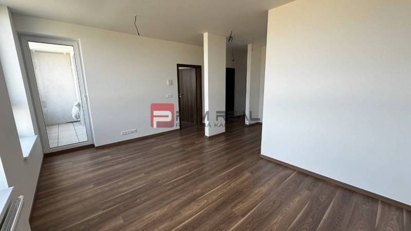 2-izbový byt Slnečnice POP pri novej električke do centra! - Interiér 2-izbového bytu s drevenou podlahou a priestranným balkónom.
