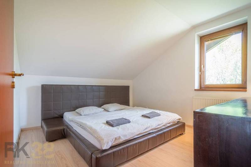Znížená cena: priestranný apartmán s TOP polohou v Starom Smokovci - Spálňa v Rekreačnom apartmáne s dvojposteľou, oknom, dreveným nábytkom a strešnými sklony.