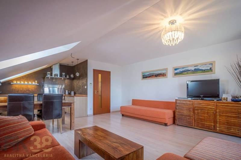 Znížená cena: priestranný apartmán s TOP polohou v Starom Smokovci - Obývacia izba Rekreačného apartmánu s pohovkami, jedálenským stolom a televíziou.