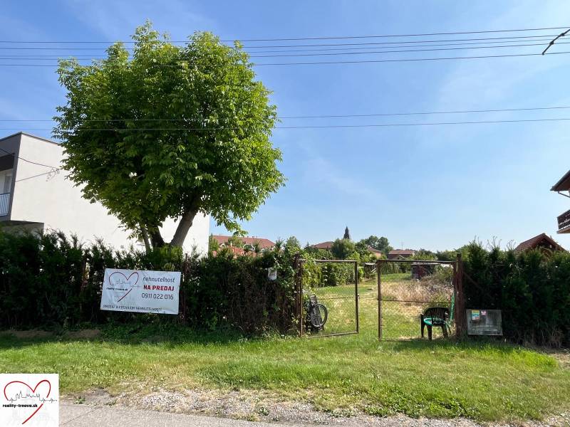 Stavebný pozemok s veľkou záhradou a potenciálom - Pozemky - bývanie v obci Dolný Bar, oplotený pozemok so stromom a bránou.