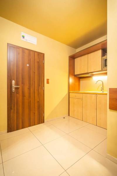 Príjemný apartmán s terasou v podhorí Vysokých Tatier - Vstupná časť Rekreačného apartmánu s drevenými dverami a kuchynskou linkou.