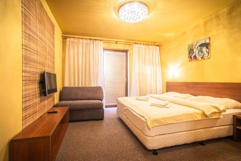 Príjemný apartmán s terasou v podhorí Vysokých Tatier - Spálňa v rekreačnom apartmáne s manželskou posteľou, pohovkou a televízorom.