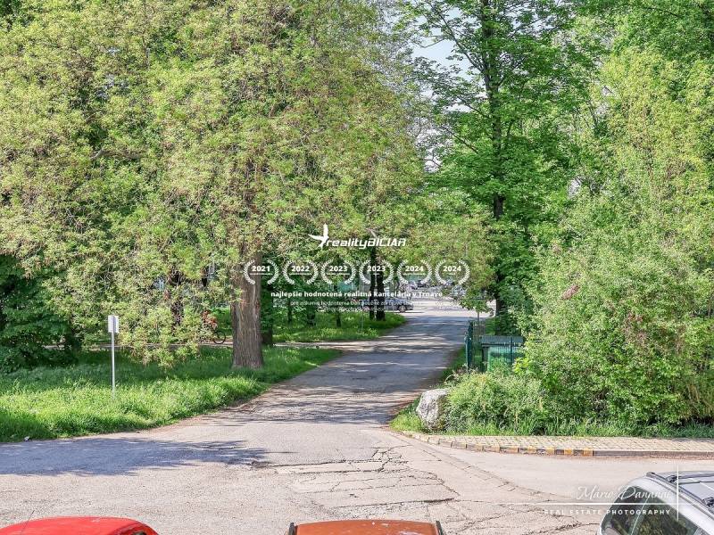 REZERVOVANÉ 2-izbový byt na Staničnej ulici v Trnave - Staničná ulica v Trnave lemovaná stromami, zobrazuje pokojnú mestskú scenériu.