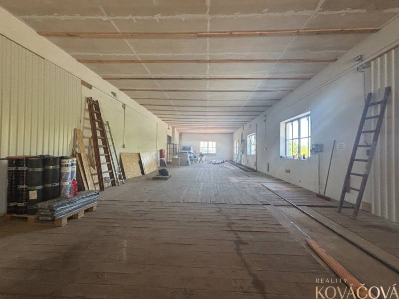 Na prenájom hala s pozemkom 4500 m² – Mníchova Lehota  - Interiér skladovej haly s rebríkmi a stavebným materiálom, Sklady a haly vhodné na prácu.
