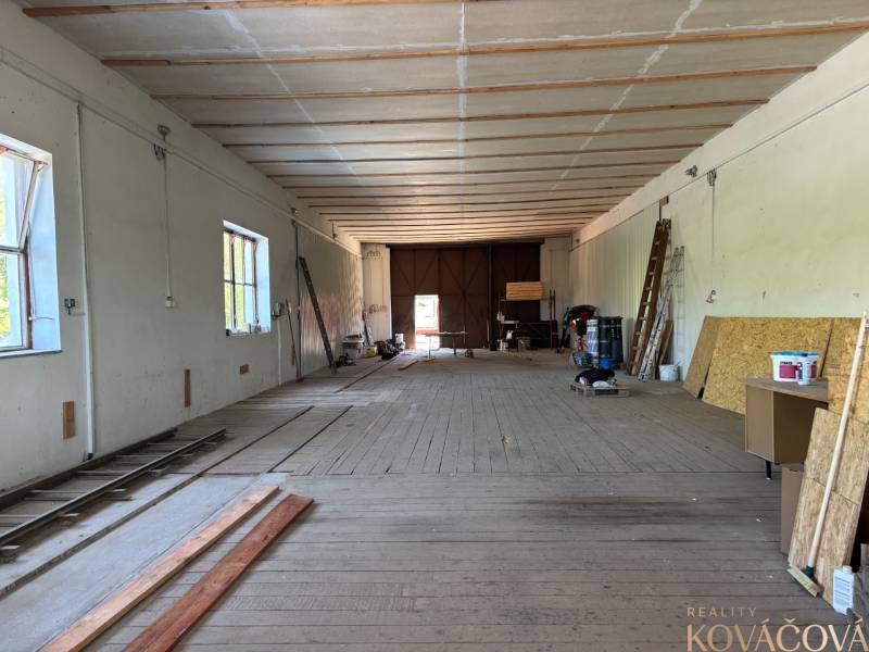 Na prenájom hala s pozemkom 4500 m² – Mníchova Lehota  - Interiér skladov a hál s drevenou podlahou, rebríky a drevené dosky na stene.