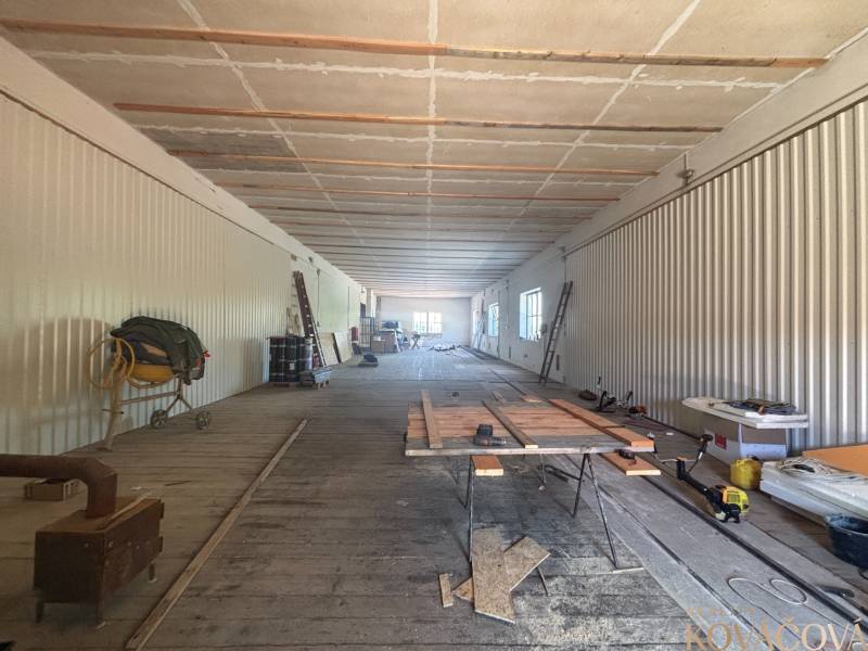 Na prenájom hala s pozemkom 4500 m² – Mníchova Lehota  - Priestranný interiér skladov a hál s drevenou podlahou, stavebným materiálom a náradím.