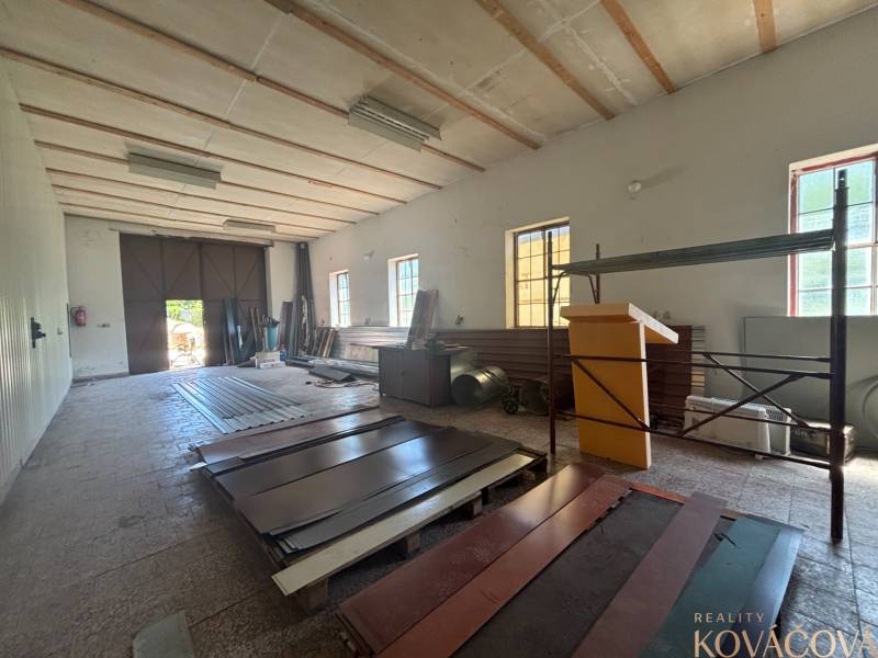 Na prenájom hala s pozemkom 4500 m² – Mníchova Lehota  - Interiér skladov a hál s plechovými materiálmi a širokou bránou na svetlo.